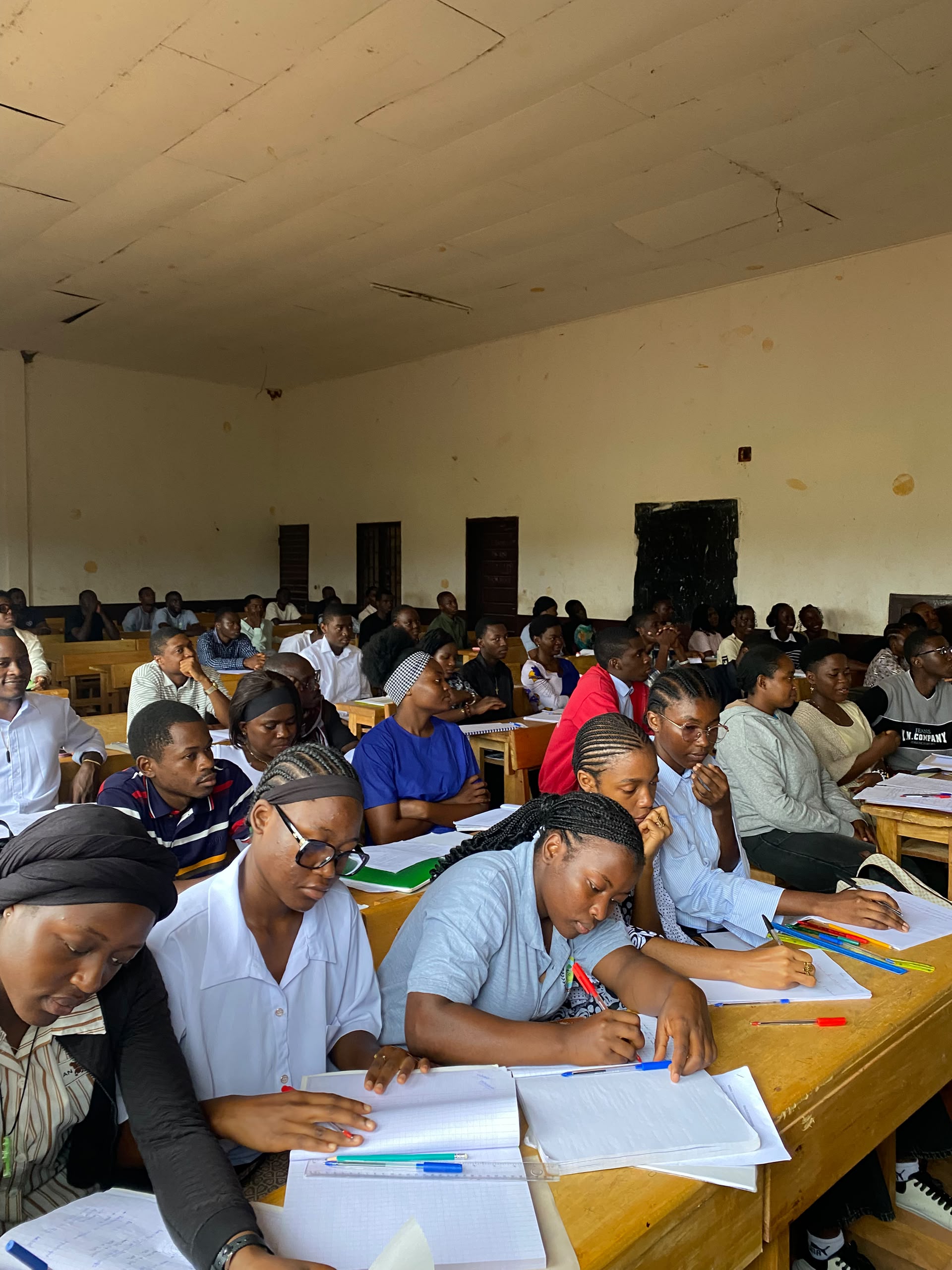 Étudiants suivant un cours en salle.